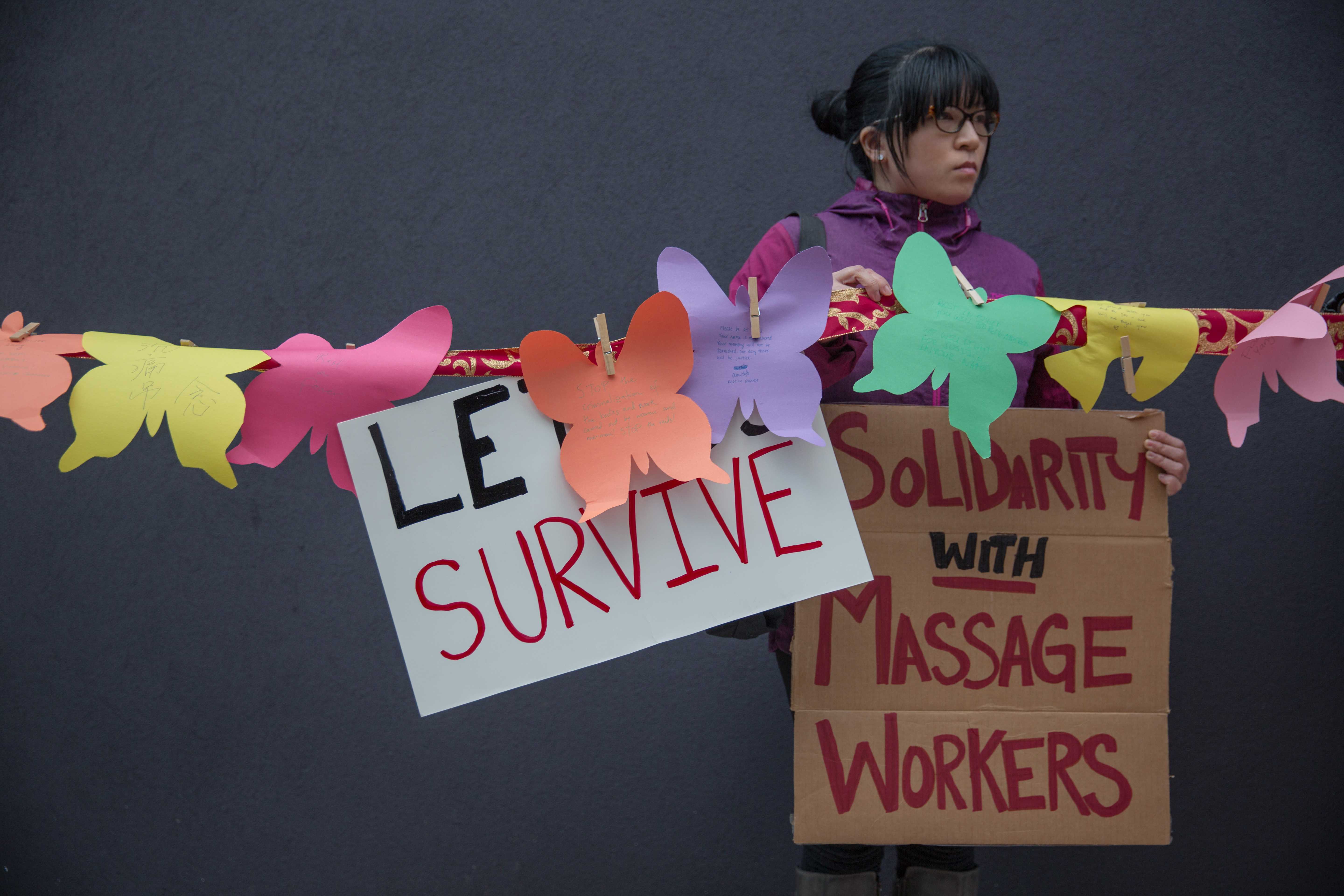 Community activist with sign: Let Us Survive