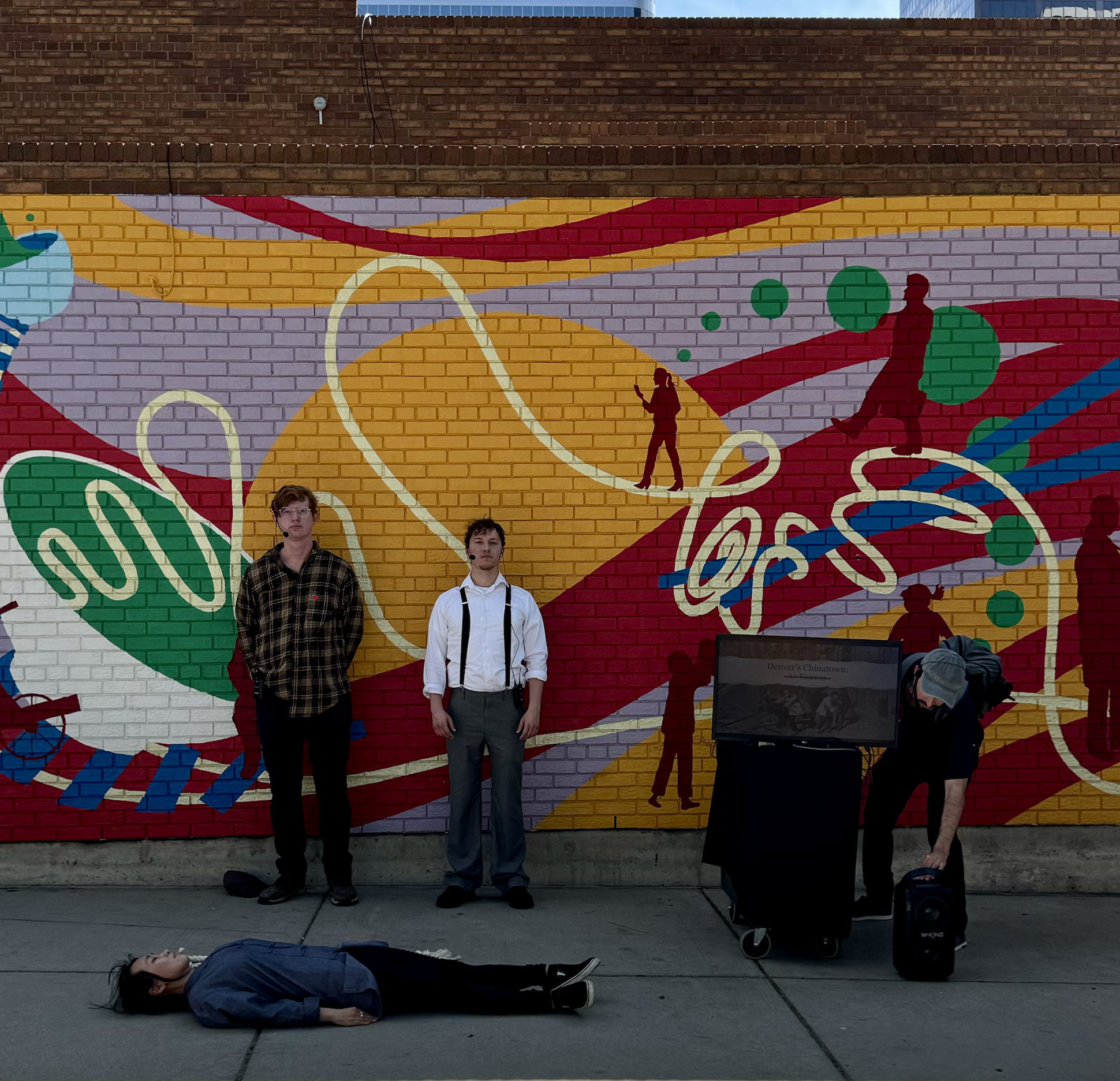 Audience reading the quotes from historic archives in front of CAPU mural
